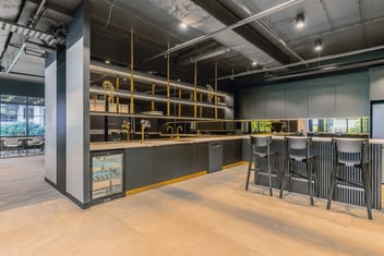 black kitchen with gold accents and exposed ceiling