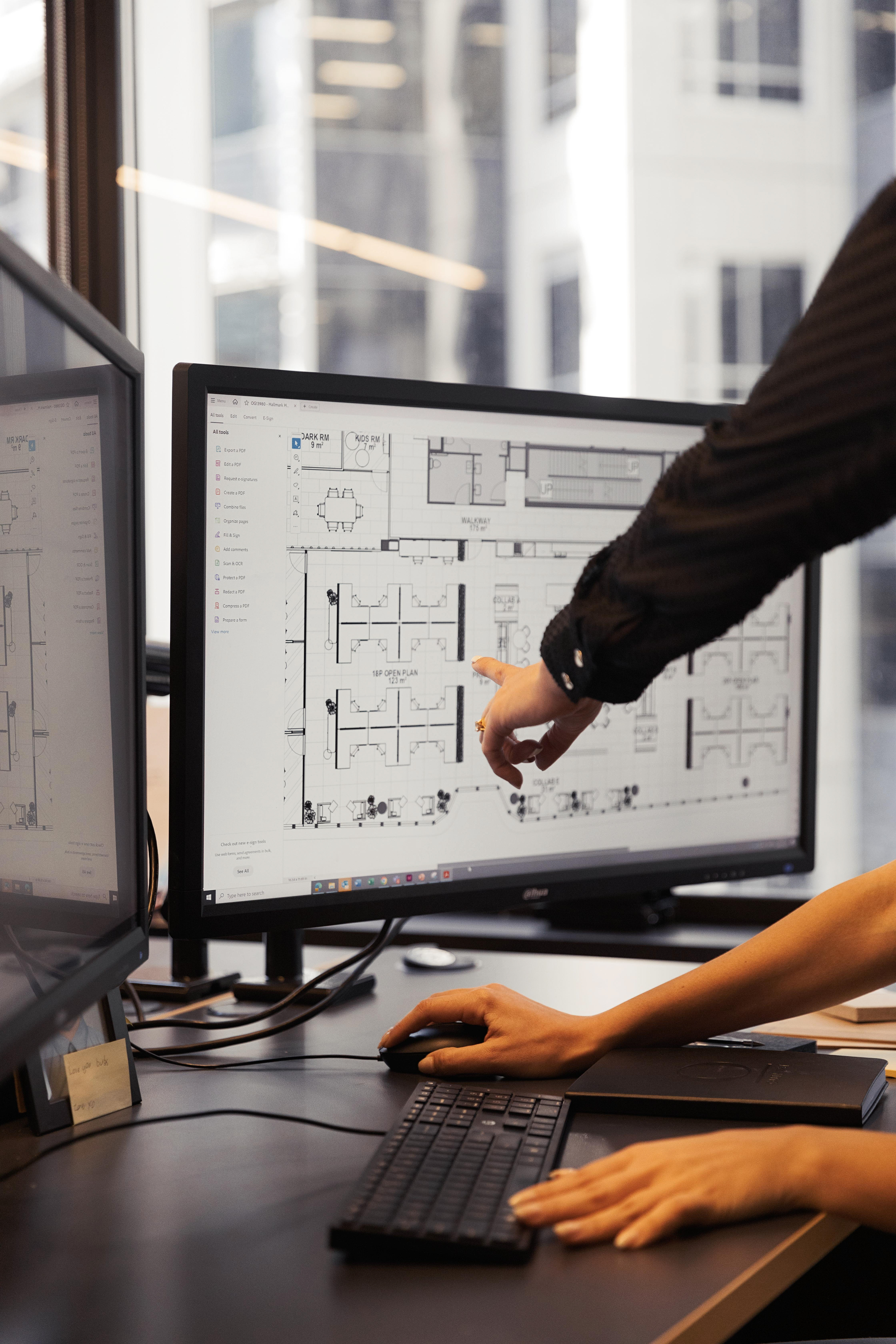 computer screen with floor plan and someone pointing