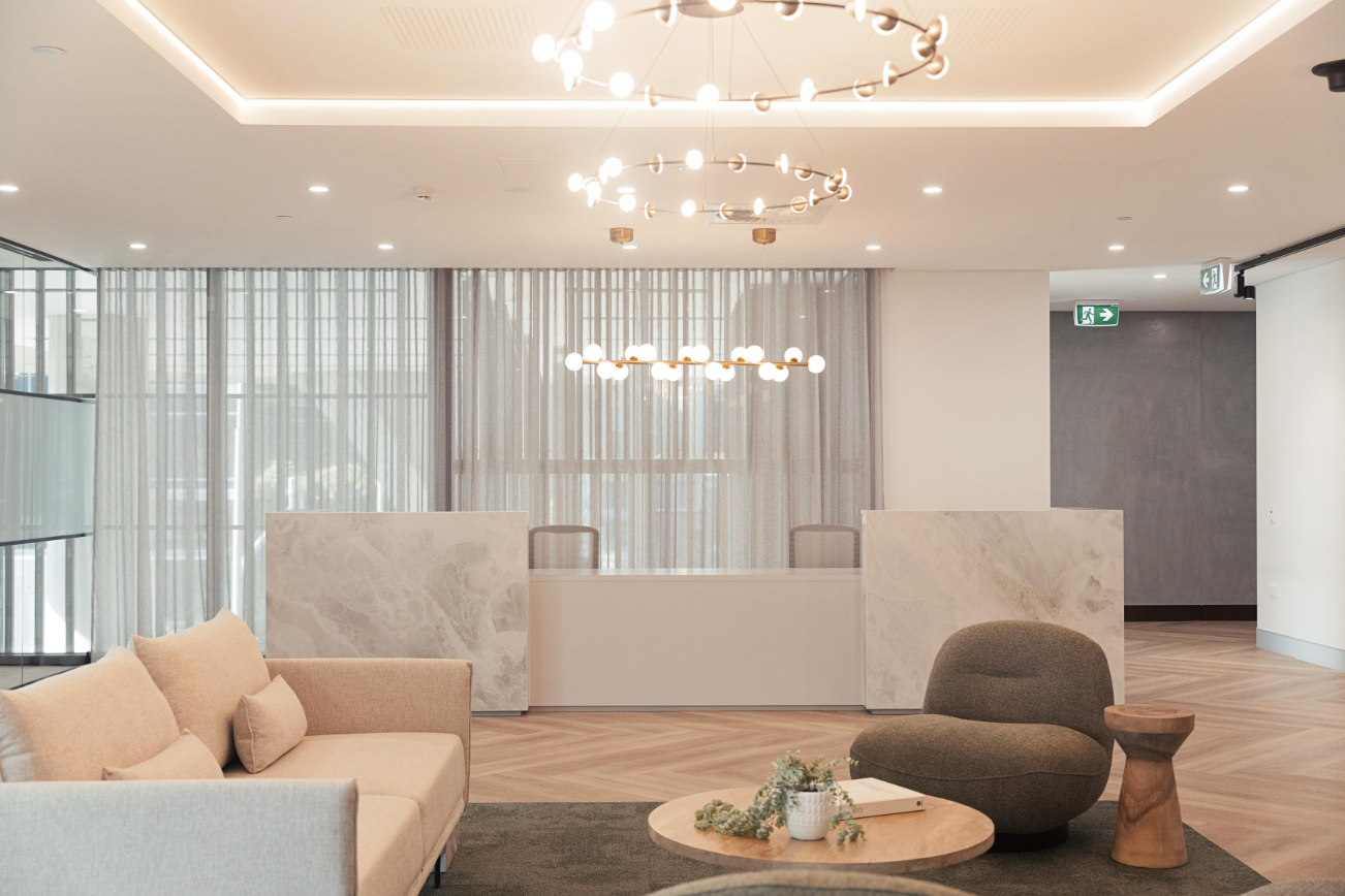 marble reception desk and waiting area with pendant lighting