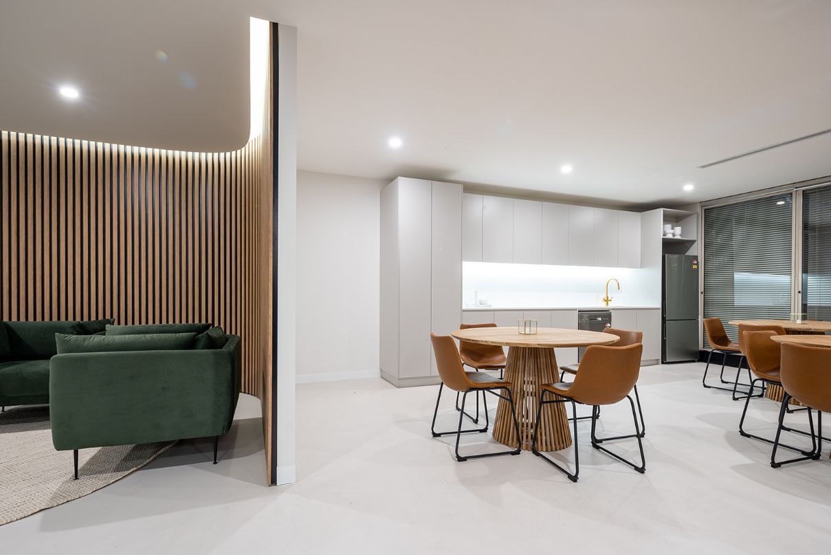 kitchen perspective of a office space featuring round tables with tan leather chairs